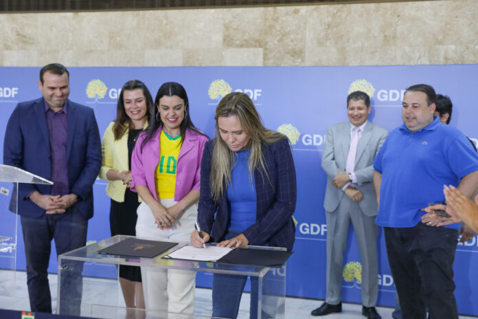 Celina Leão assinando documento que decreta ponto facultativo em jogos da seleção brasileira na Copa do Mundo Feminina